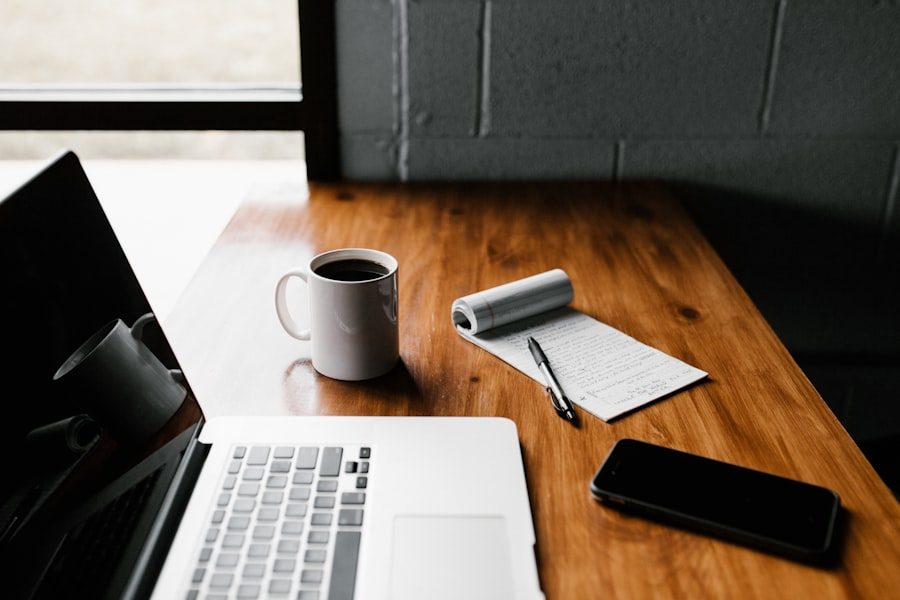 A laptop and notebook on a desk